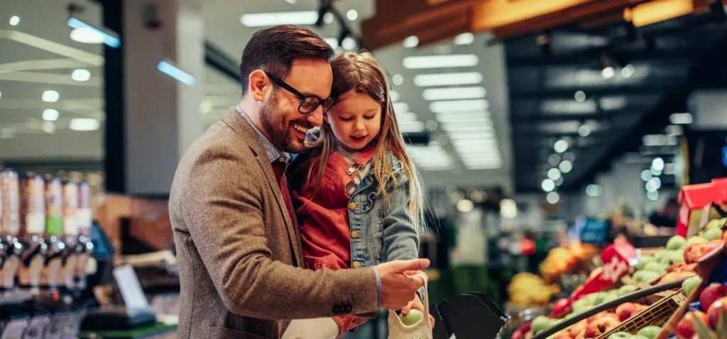 Father and his cute daughter buying fruits in super marker