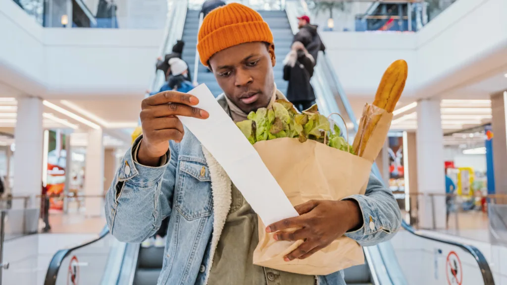 Young male going through the grocery bill at the mall